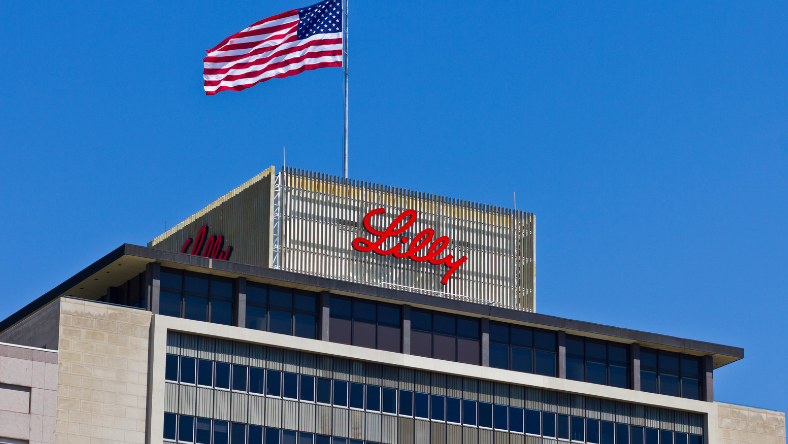 Eli Lilly signage on a pharmaceutical company building with a US flag above