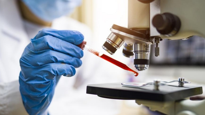 Scientist analyzing peptide samples under a microscope during early-stage drug research