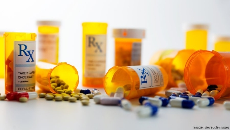 Prescription pill bottles and capsules representing peptide drug development