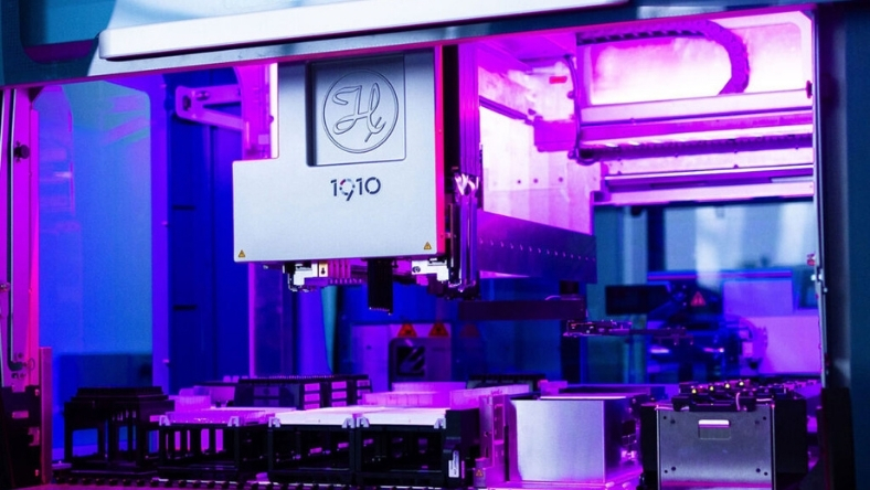 Automated laboratory instrument inside biotech research facility under purple lighting